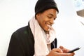 Close up handsome young african american man smiling and looking at cellphone by white background Royalty Free Stock Photo