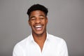 Close up handsome young black man laughing against gray background Royalty Free Stock Photo