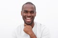 Close up handsome young black man smiling with hand to chin against white wall Royalty Free Stock Photo