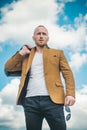 Close-up of handsome young man wearing suit jacket, sunglasses and looking away while standing against cloudy sky. Mr Royalty Free Stock Photo