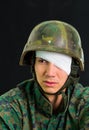 Close up of handsome young soldier wearing uniform suffering from stress, with a white bandage around his head and Royalty Free Stock Photo