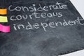 Close up of handwritten educational values: considerate, courteous and independent. Chalk on a blackboard.