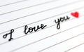 Close-up handwritten phrase `I love you` and red heart.