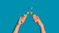 Close up of handyman holding flat nose pliers on blue background, panorama Royalty Free Stock Photo