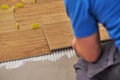 Close-up of handyman placing tile spacer. Placing the floor tiles. Home improvement
