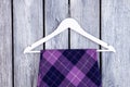 Close up hanger and purple checkered clothes.