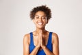 Close-up of happy african-american sportswoman saying thank you, looking grateful, holding hands pressed together