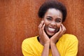 Close up happy african american woman laughing against brown rust background