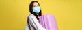 Close up of happy asian girl tourist in medical face mask, holding pink cute suitcase, going on vacation, travelling