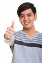 Close up of happy Asian man smiling and giving thumb up