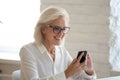 Close up happy attractive 60 years old businesswoman using smartphone. Royalty Free Stock Photo