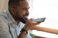 Close up happy black man dictating voice message.