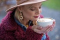 Pretty young woman smelling coffee with enjoyment Royalty Free Stock Photo