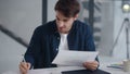 Smiling guy making notes on financial diagram. Man enjoying results of project Royalty Free Stock Photo