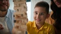 Close-up happy caucasian family mom dad son having fun playing Jenga caring parents play with beloved child boy in Royalty Free Stock Photo