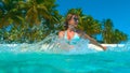 CLOSE UP: Happy tourist girl splashing the turquoise sea water with her hands Royalty Free Stock Photo