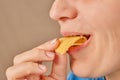 Close-up of a happy Caucasian woman holding a slice of cheese with her hand and biting it. Side view. Low angle view Royalty Free Stock Photo