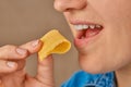 Close-up of a happy Caucasian woman holding a slice of cheese with her hand and bringing it to her mouth. Front three-quarter view Royalty Free Stock Photo