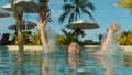 CLOSE UP: Happy Caucasian woman jumping out of pool glistens in exotic sun rays Royalty Free Stock Photo