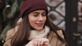 Close Up of Happy Charming Young Brunnete Girl Wearing Winter Hat, Feeling Cold Warming her Hands and Smiling, Waiting