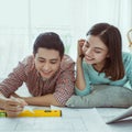 Close up of happy couple looking at blueprint at home