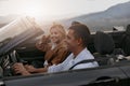 Close up of happy couple man and woman traveling driving a convertible car, side view Royalty Free Stock Photo