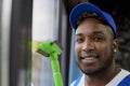 Closeup of happy face of a black blue-uniformed worker cleaning the premises