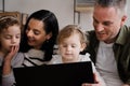 Close up of happy family watching movies on laptop sitting together on sofa in lounge.