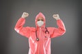 close up of happy female doctor standing wearing PPE and mask with two hands raised up