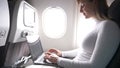 CLOSE UP: Happy journalist writing a blog post during her transatlantic flight.
