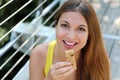 Close up of happy fitness woman holding an energy bar. Sporty girl eating a muesli bar outdoor Royalty Free Stock Photo
