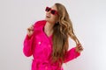 Close up happy girl in red sunglasses and pink coat isolated on white background. excited, shock and surprised young woman in