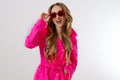 Close up happy girl in red sunglasses and pink coat on white background. excited, shock and surprised young woman