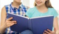 Close up of happy girls reading book at home Royalty Free Stock Photo