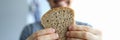 Close up happy guy holds piece whole grain bread