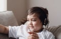 Close up Happy kid with smiling face,  Head shot positive child wearing headphone listening music in retro filter, Yong boy siting Royalty Free Stock Photo
