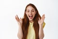 Close up of happy laughing redhead woman, clap hands and smiling amazed, checking out awesome promo offer, great news