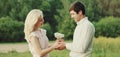 Close up of happy lovely young couple holding bouquet of wildflowers together over green summer background Royalty Free Stock Photo