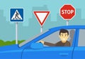 Close-up of a happy male driver in a blue car. Student driver on a test road with traffic signs. Royalty Free Stock Photo