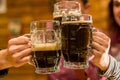 Close up of a happy male friends clinking with beer mugs in pub Royalty Free Stock Photo