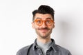 Close-up of happy man with moustache and glasses looking at camera, smiling pleased, standing against white background Royalty Free Stock Photo