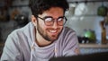 Close up of happy man working on laptop in kitchen at home at night Royalty Free Stock Photo