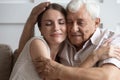 Loving mature dad and daughter cuddle at home together