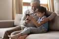 Close up happy mature grandfather and grandson using phone together Royalty Free Stock Photo