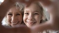 Close up happy mature grandmother and granddaughter showing heart gesture Royalty Free Stock Photo