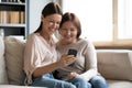 Close up happy mature mother and grownup daughter using phone Royalty Free Stock Photo
