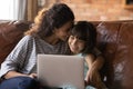 Close up happy mother and little daughter hugging, using laptop Royalty Free Stock Photo