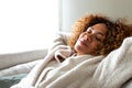 Close up of happy multiracial woman sleeping resting lying on the sofa with arms behind the head at home. Copy space.