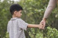 Close up of happy mum and son holding hand in a park. Royalty Free Stock Photo