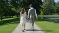 CLOSE UP: Young happy couple holding hands gaze at each other walking in park Royalty Free Stock Photo